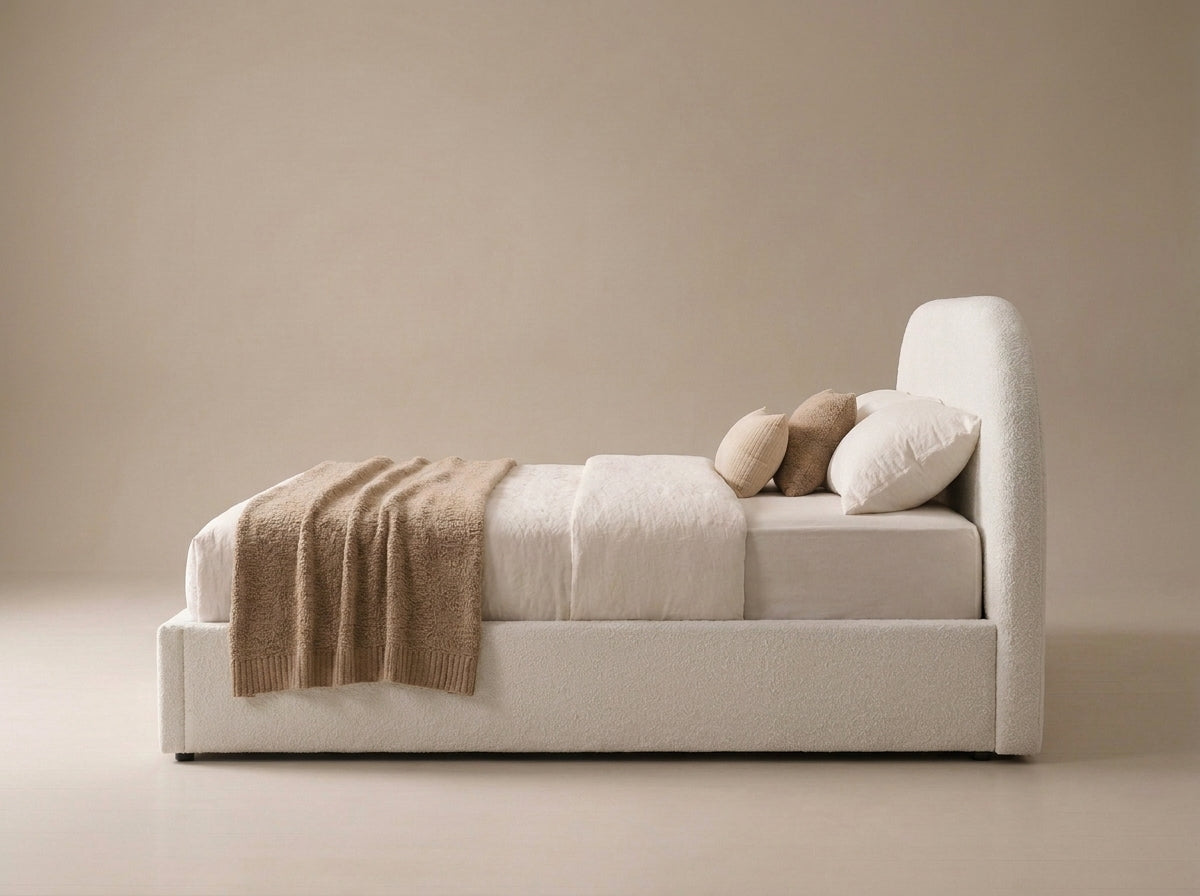 Side view of the Velets Flora ivory boucle upholstered bed showing headboard and low base.